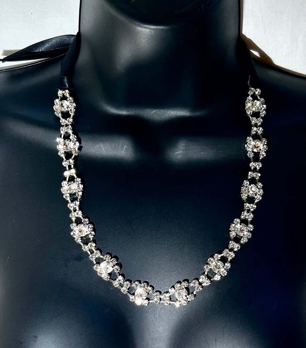 Elegant Rhinestone and black ribbon necklace with silver tone base metal.